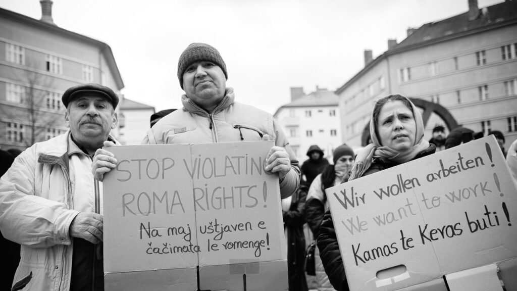 Beitragsbild zum Protestbrief "Moldau ist kein sicheres Herkunftsland!". Zu sehen sind drei Personen. Sie halten Demoschilder. Auf denen steht jeweils in den Sprachen Deutsch, Romanes und Englisch: "Schluss mit der Verletzung der Roma-Rechte!" und "Wir wollen arbeiten!"